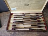 eight knives in a case sitting on a table