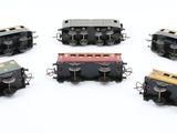 six different colored trains sitting on a white surface