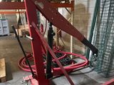 une grosse machine rouge qui se trouve dans un entrepôt
