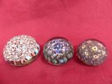 three glass buttons sitting on top of a red cloth