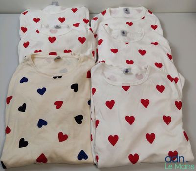 trois t-shirts ornés de cœurs, posés sur une table