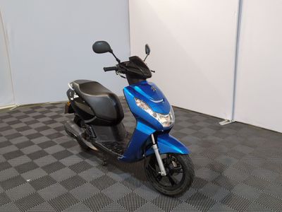 un scooter bleu garé dans une pièce au sol à carreaux