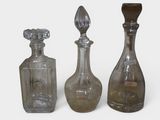 three glass bottles are lined up next to each other on a white surface