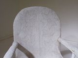 a white chair that is sitting in the corner of a room