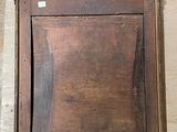 an old wooden clock on the wall next to a window