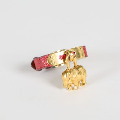 un bracelet rouge orné d'une breloque en forme d'éléphant doré