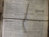 an old newspaper with a cross on top of it sitting on top of a table