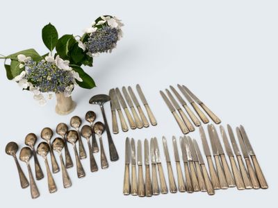 beaucoup de cuillères et de couteaux à cuillère et un vase de fleurs