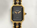 a black and gold watch with a chain around it