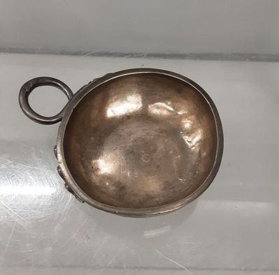 a small metal bowl on a white surface