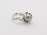 a black pearl and diamond ring on a white background
