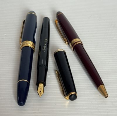 trois types de stylos différents sont alignés sur une surface blanche