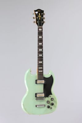 un gros plan d'une guitare électrique verte sur fond blanc