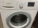 une machine à laver surmontée d'un sèche-linge