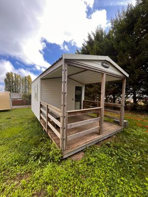 une photo d'une petite cabane dans l'herbe