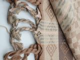 an image of a brown and tan blanket with a tassel