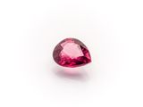 a close up of a pink tourmaline gemstone on a white surface