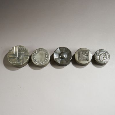 four different types of coins are arranged in a row on a white surface