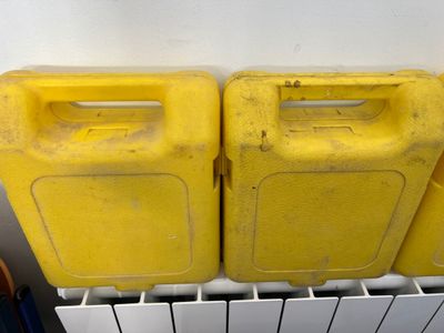 two yellow plastic containers sitting on top of a radiator