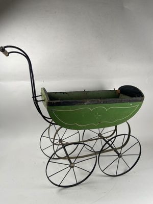 a green baby stroller with a black handlebar