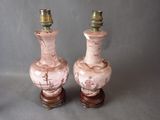 deux vases roses posés l'un à côté de l'autre sur une table
