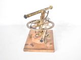 a small brass model of a telescope on a wooden base