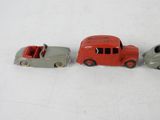 three toy cars sitting next to each other on a white surface