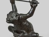 bronze statue of a monkey holding a golf club on a marble base