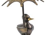 a statue of a duck with an umbrella on a pedestal