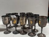 several silver goblets and cups are lined up on a table