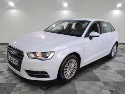 une Audi blanche garée sur un sol à damier dans un garage