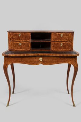 un bureau ancien muni de tiroirs et d'un plateau en marbre