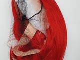 a red wig with a veil on top of it