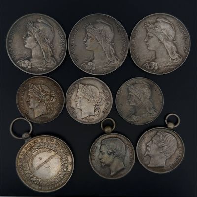six different types of silver coins on a black surface