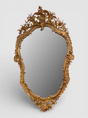 un miroir sculpté avec un cadre doré sur fond blanc