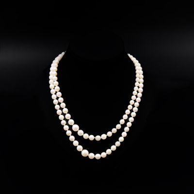 un collier de perles blanches composé de deux rangs de perles, posé sur un mannequin noir