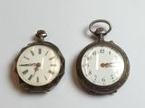 deux horloges posées côte à côte sur une surface blanche