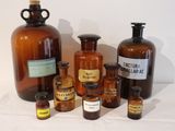 bottles of various sizes and shapes are lined up on a white surface