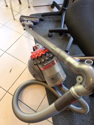 a vacuum that is sitting on the floor next to a chair