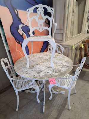 a white table and chairs in a room with a painting on the wall