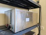 une boîte en métal posée sur une étagère en métal