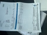 une pile de papiers posée sur une table, à côté d'un ordinateur portable