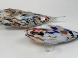 two glass birds that are sitting next to each other