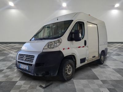 une camionnette blanche garée sur un sol en damier