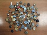 a pile of buttons on a table with a red button