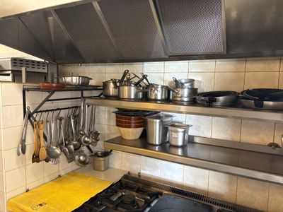 de nombreuses casseroles et poêles sur les étagères de la cuisine