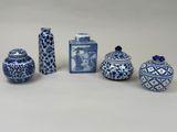 five blue and white vases and a vase with a lid