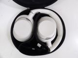 two white headphones in a black case on a white table