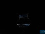 a glass vase sitting on top of a table in the dark
