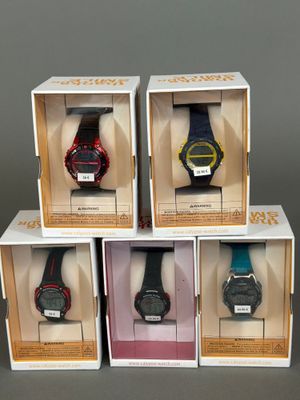 trois boîtes contenant quatre montres différentes, posées sur une table